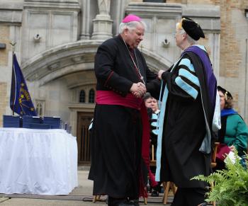 President Carol Ann Mooney presents Bishop John D'Arcy with the President's Medal at the 2010 Commencement.